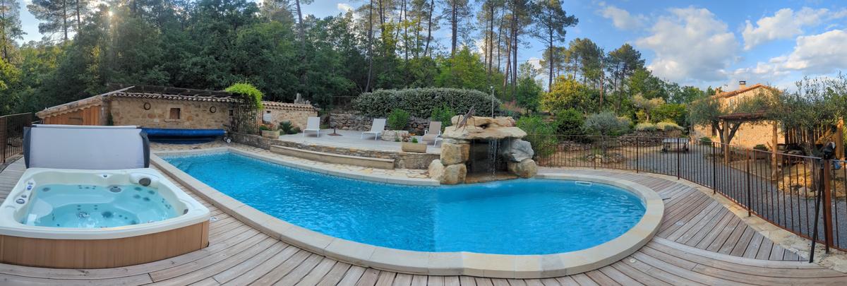 Vue panoramique de la piscine, du spa et de la terrasse en bois