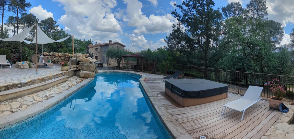 Vue panoramique de la piscine, du spa et du mas en arrière-plan
